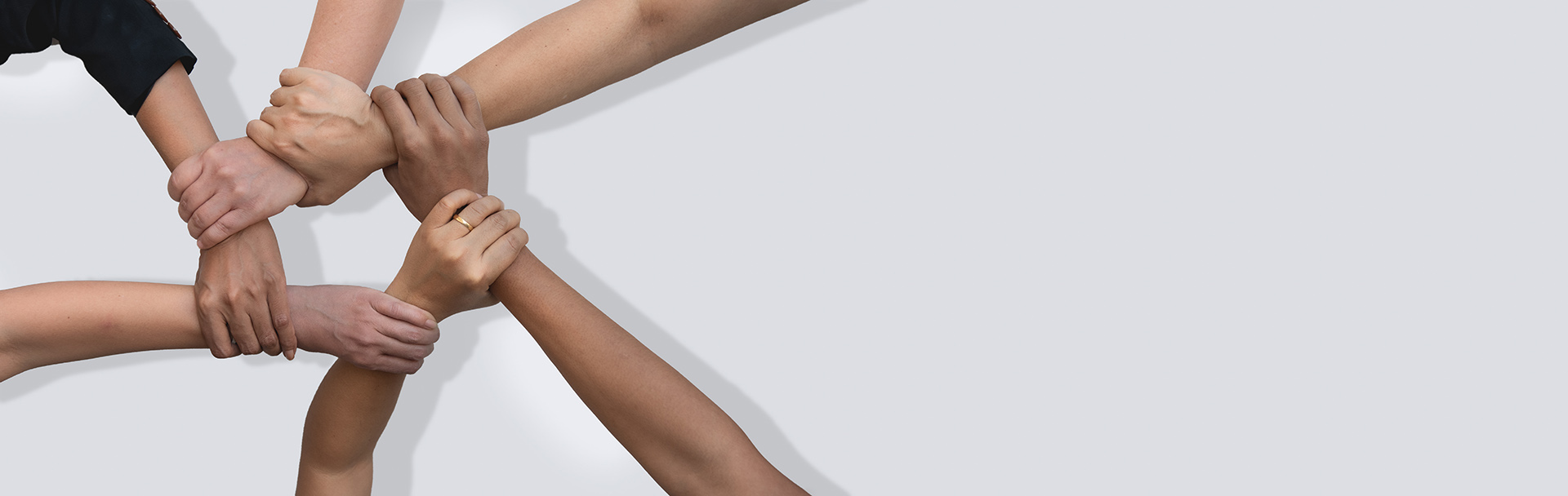Business people united hands together in teamwork on white backg